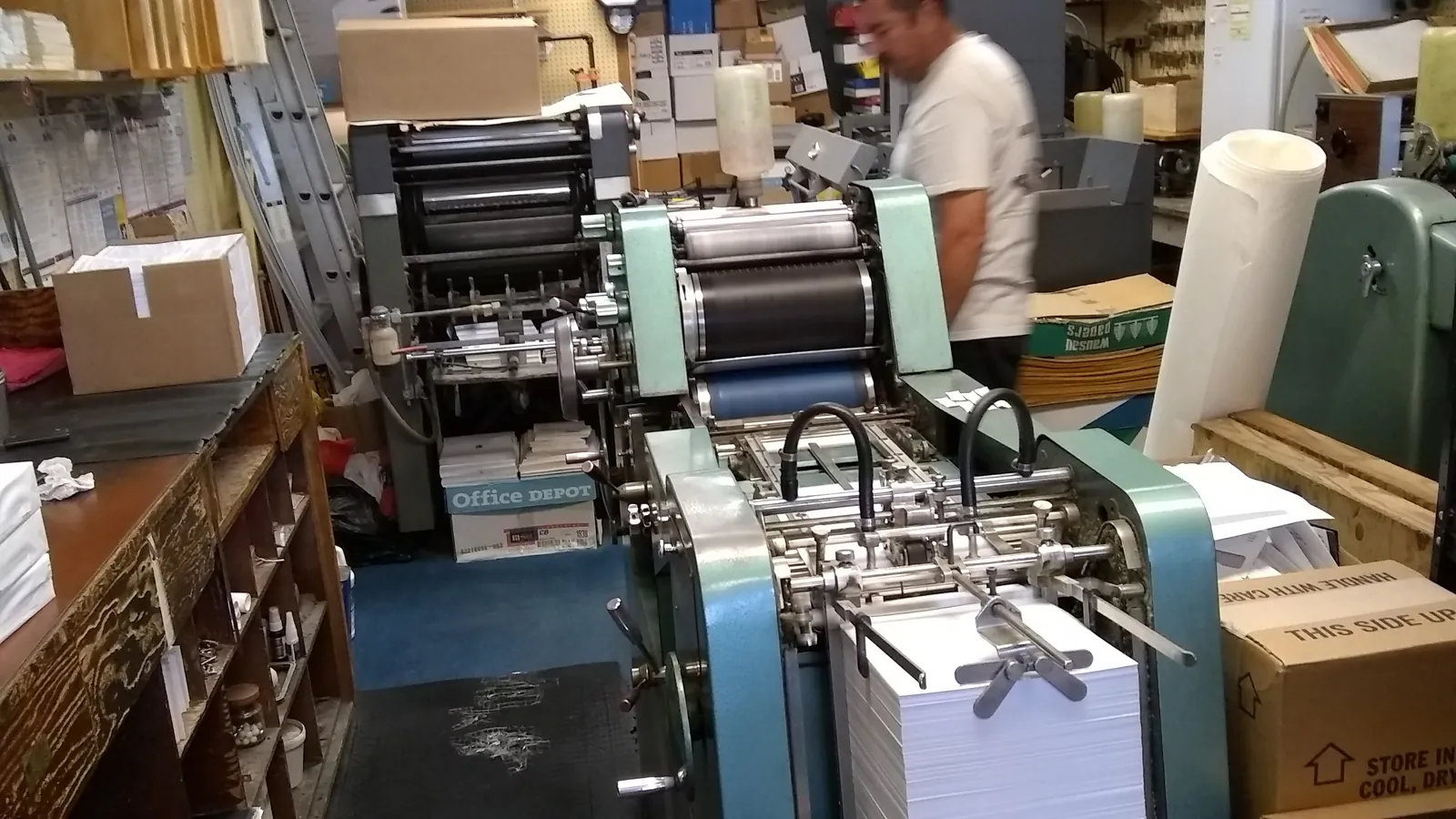An offset press running a job in the Precision Instant Printing shop.